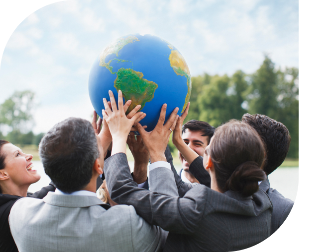 People holding a globe outdoors, smiling.
